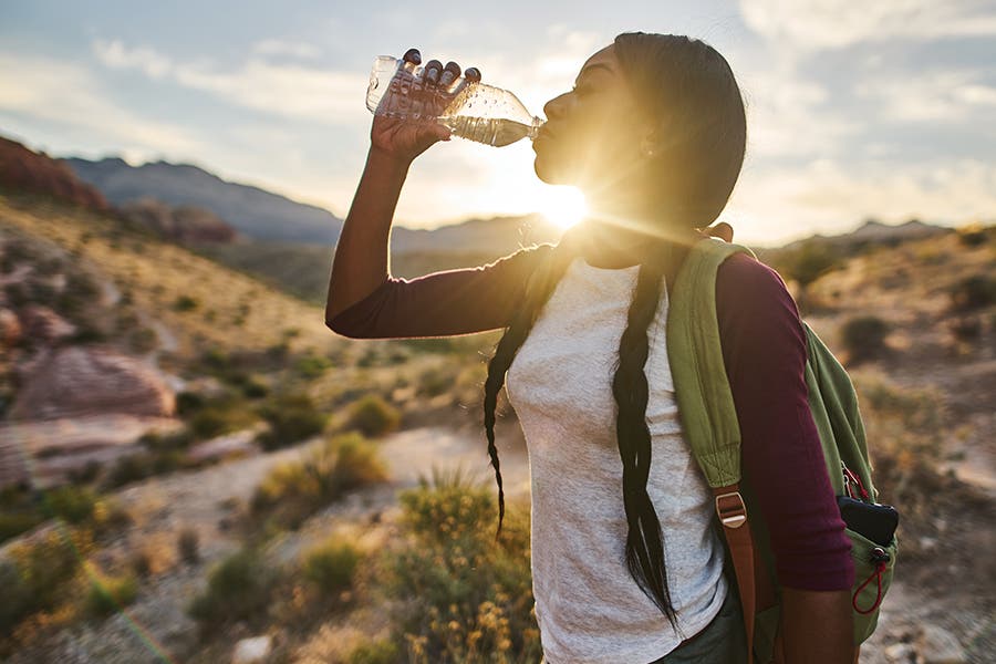 Woman drinking plastic water bottle