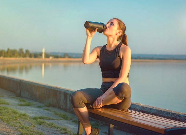 break it down build it up Fit woman drinking water outdoor workout