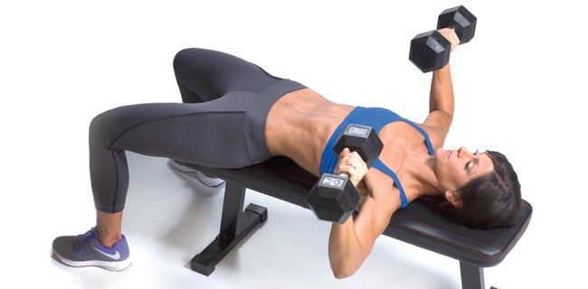 Premium Photo  Fit woman trains chest muscles doing bench press with  dumbbells in hands while lying on an incline bench in the gym