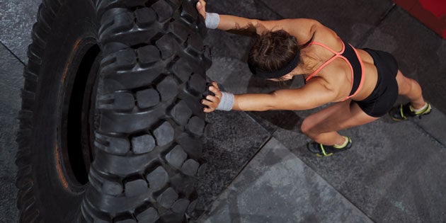 Fit woman working out with tire