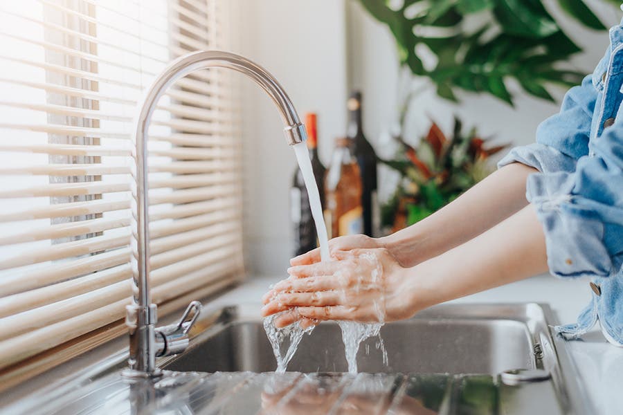 Woman washing her hands in the kitchen
