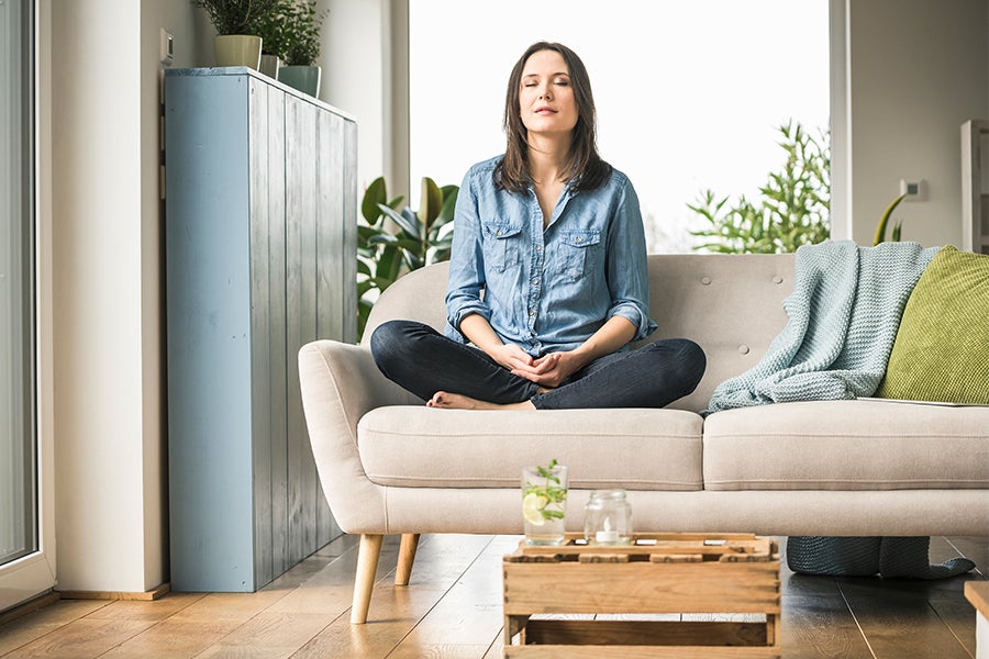 Woman closing her eyes and relaxing on a couch