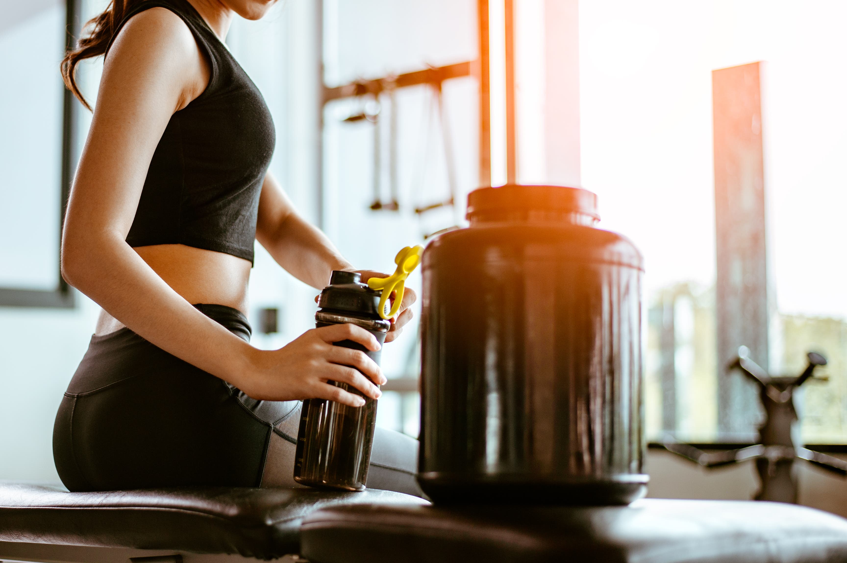 woman drinking protein shake between workouts