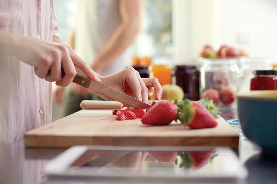 Woman cutting strawberries in the kitchen