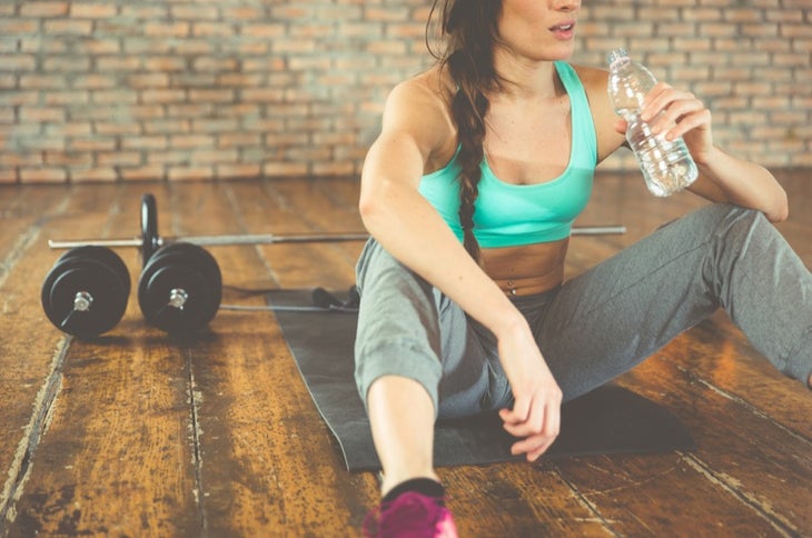 don't overdo it Woman drinking water after a HIIT workout