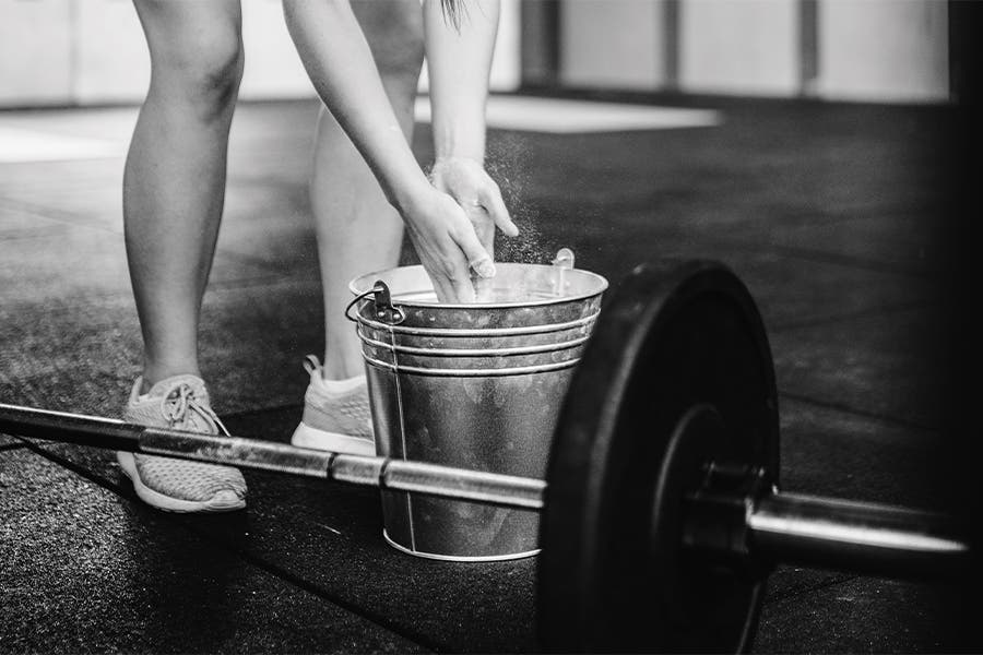 Lifting Weights Woman using chalk before lifting weights