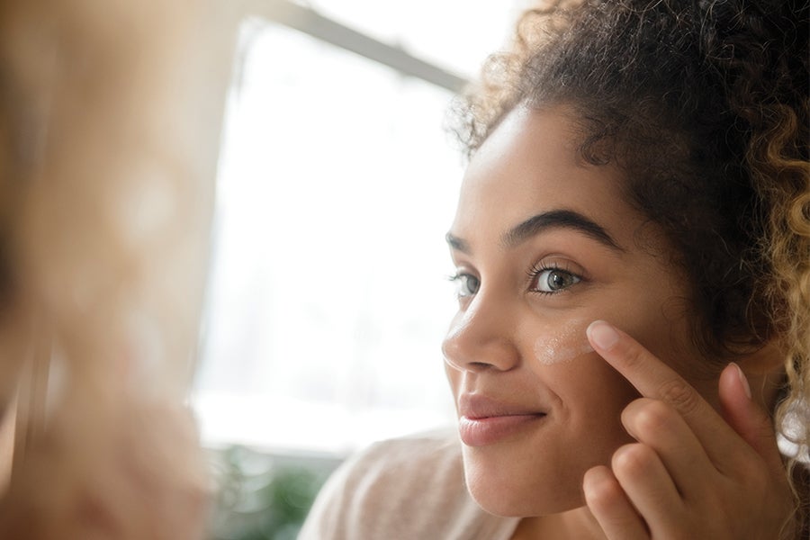 Woman doing skincare in the mirror