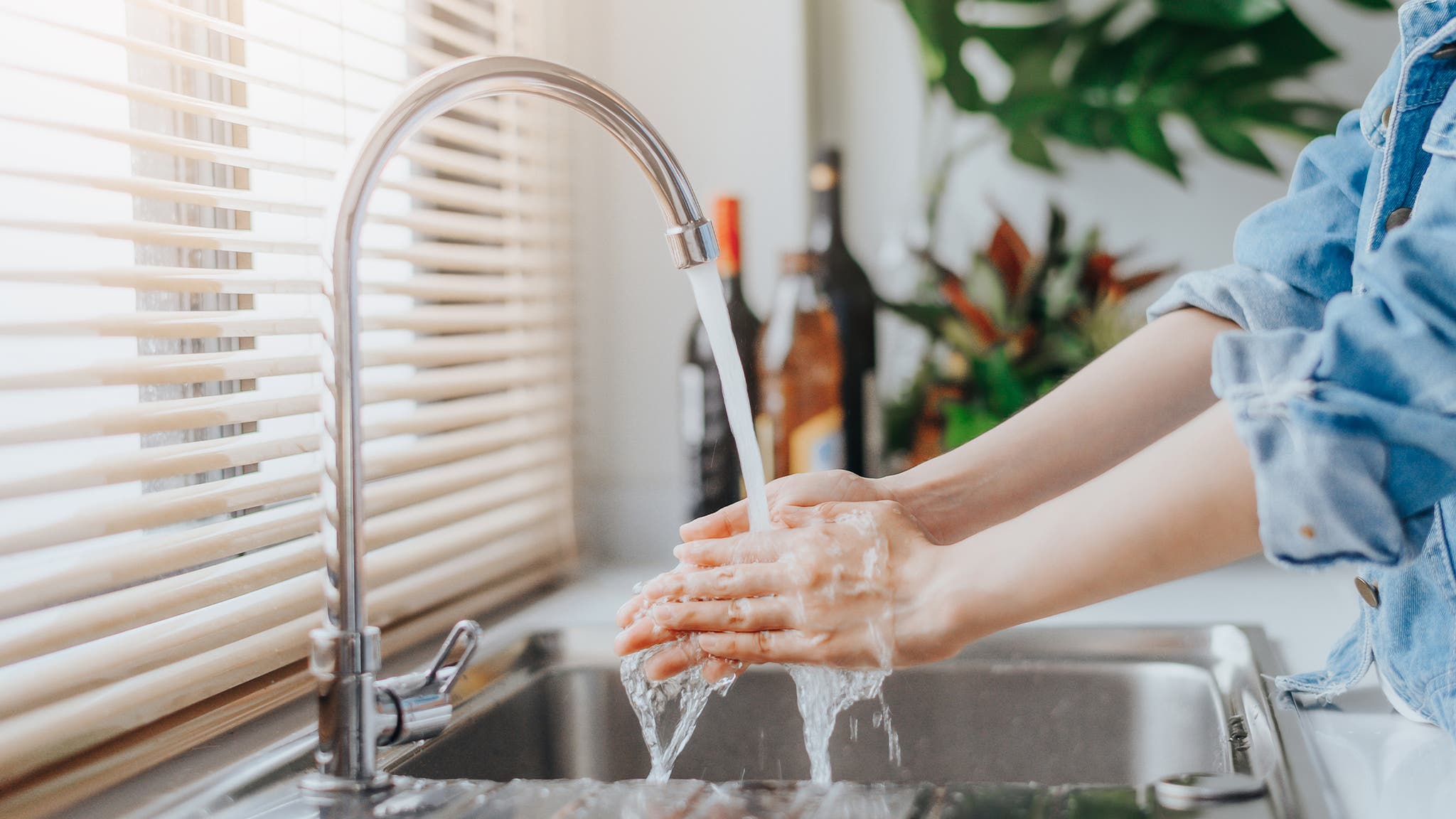 Woman washing her hands with soap and water