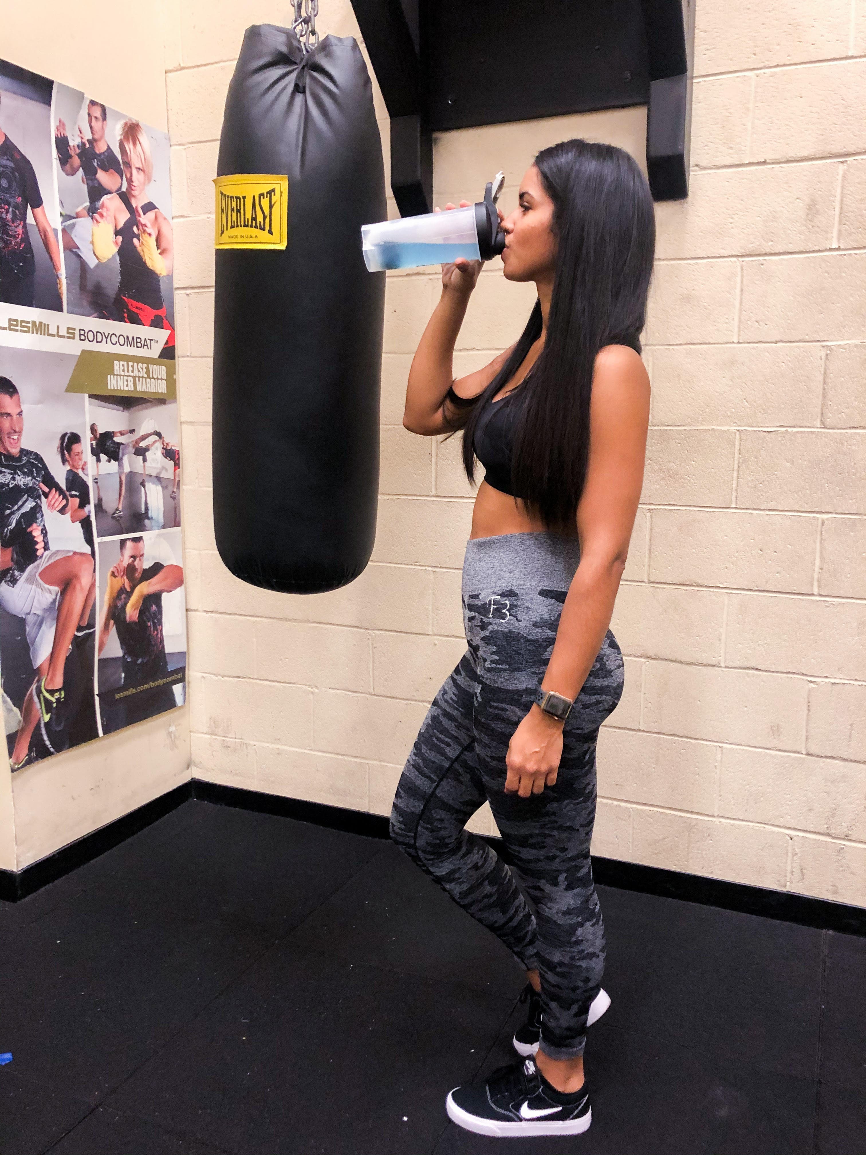 Twanny Gomes De Sa Twanny drinking her pre-workout in front of punching bag