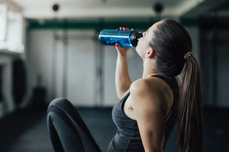Water Bottle Woman drinking water in the gym
