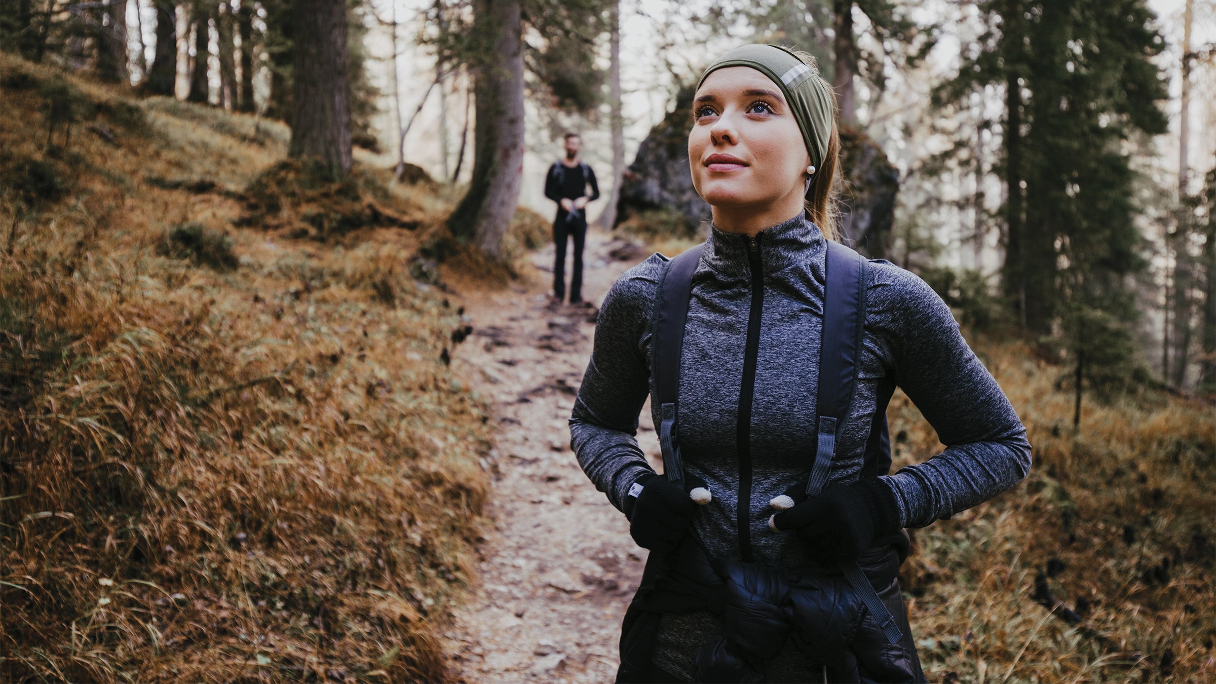 Woman and man hiking outdoors in the woods.