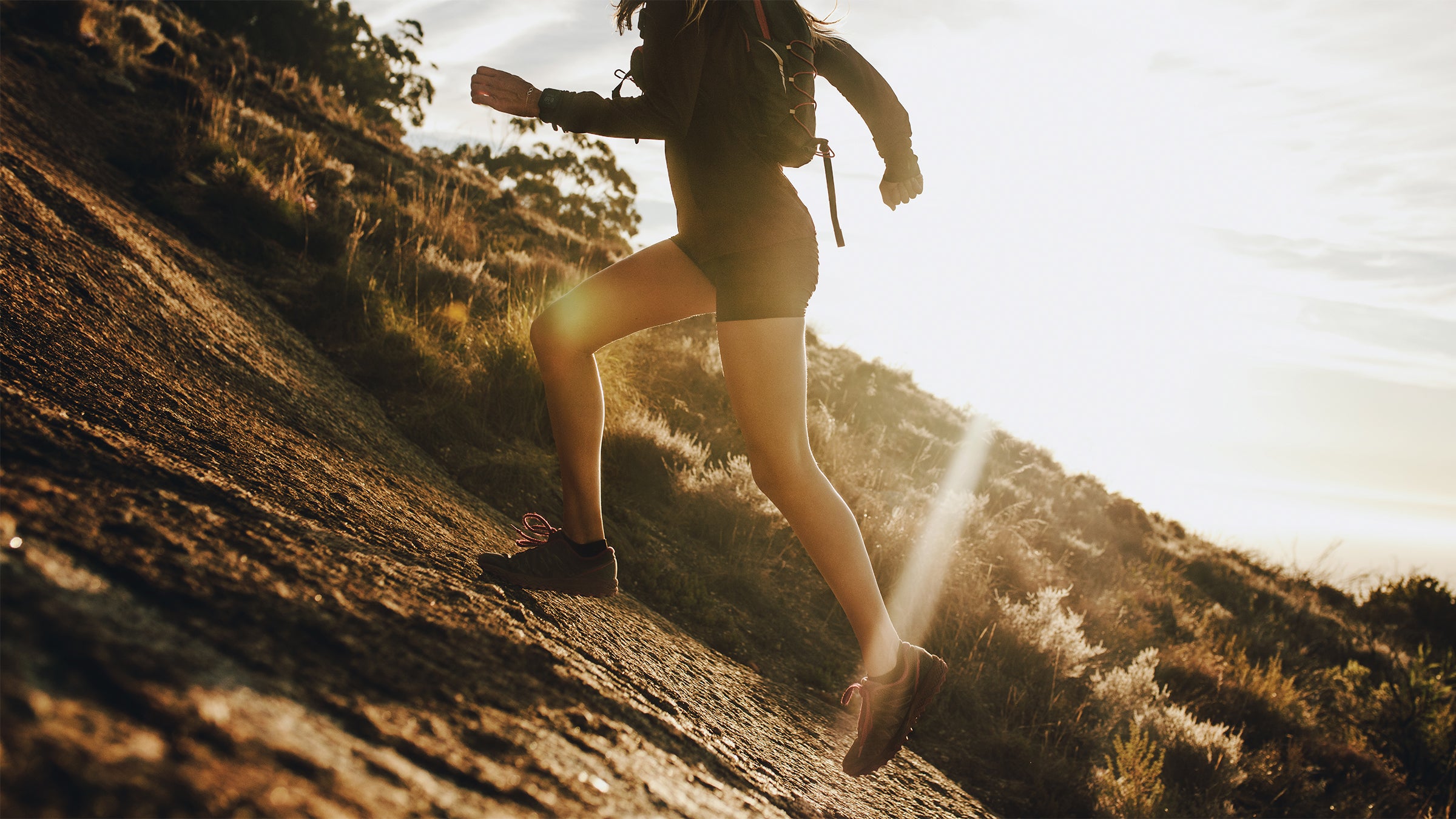 Woman running uphill outdoors.