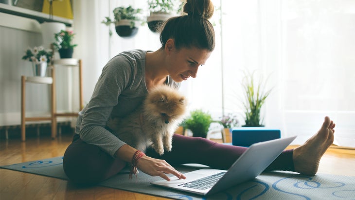 Woman working on computer after finishing up yoga.