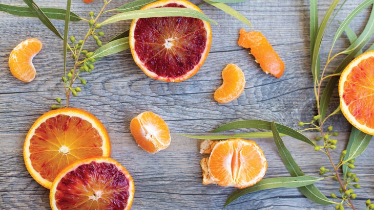 Blood oranges and clementines on a wood background.