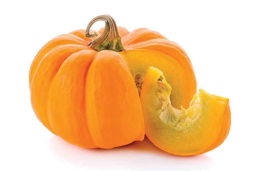 Pumpkin with a slice cut out on white background